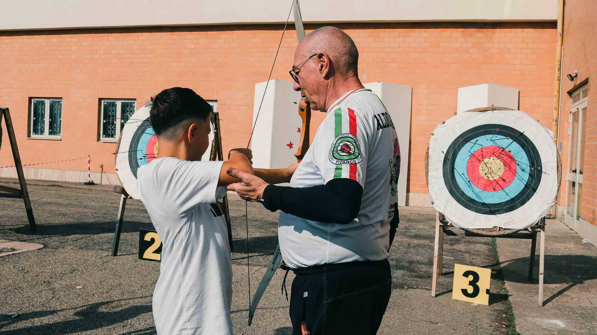 Un bambino prova il tiro con l'arco con l'istruttore federale
